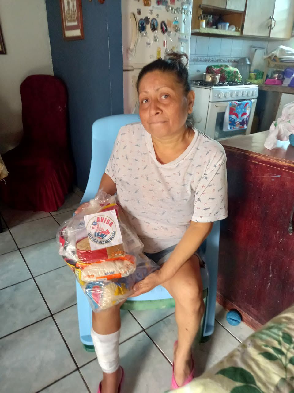Recipient holding a food package while seated at home